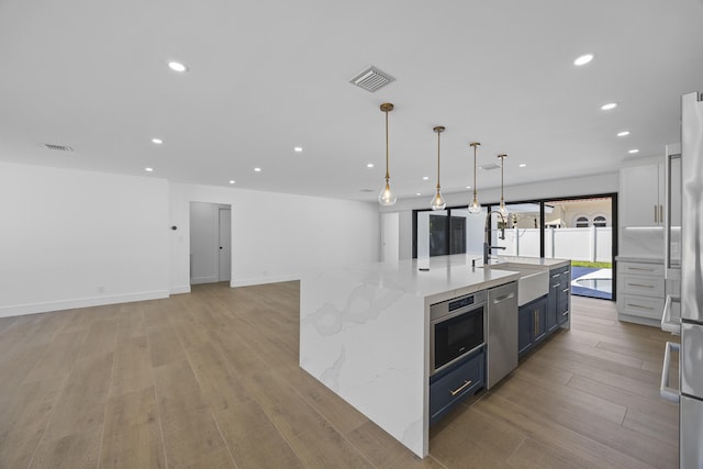 kitchen featuring recessed lighting, light wood-type flooring, visible vents, and a sink