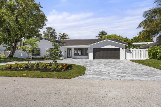 ranch-style home featuring stucco siding, fence, decorative driveway, and a garage