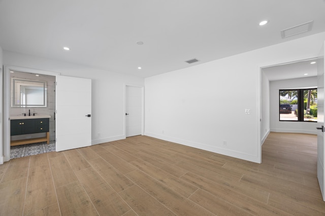 spare room with baseboards, light wood-style floors, visible vents, and recessed lighting