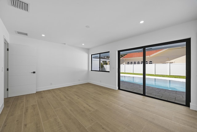 spare room with recessed lighting, wood finished floors, and visible vents