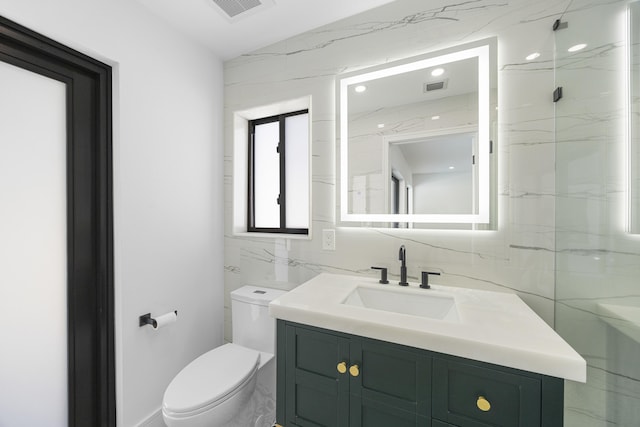 bathroom with tile walls, visible vents, vanity, and toilet