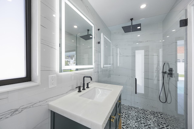 bathroom with recessed lighting, tile walls, vanity, and a marble finish shower