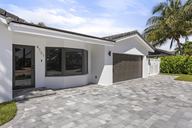 view of front of house with an attached garage, driveway, and stucco siding