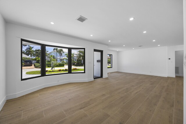 unfurnished living room with recessed lighting, visible vents, and a healthy amount of sunlight