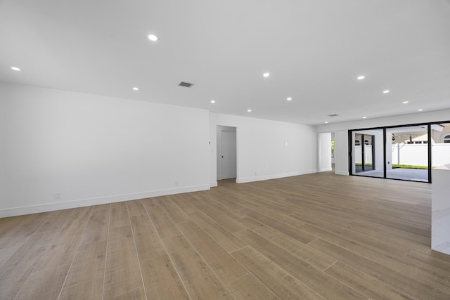 empty room featuring recessed lighting, light wood-type flooring, visible vents, and baseboards
