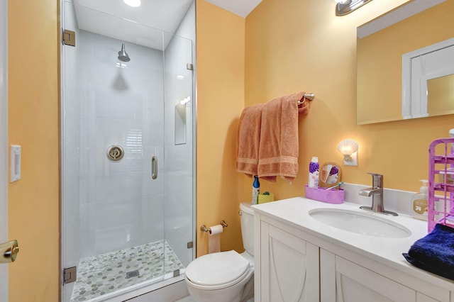 bathroom with a stall shower, vanity, and toilet