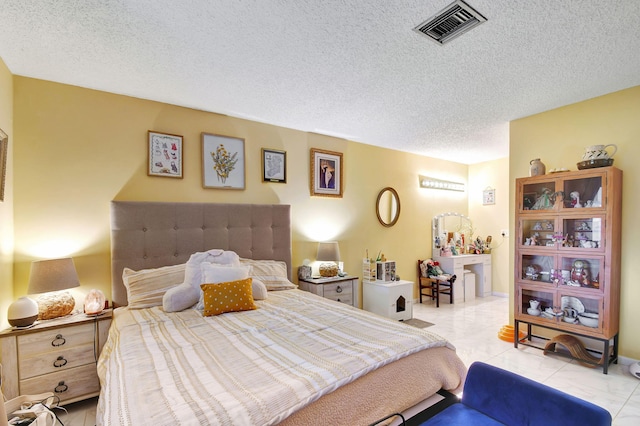 tiled bedroom with visible vents and a textured ceiling