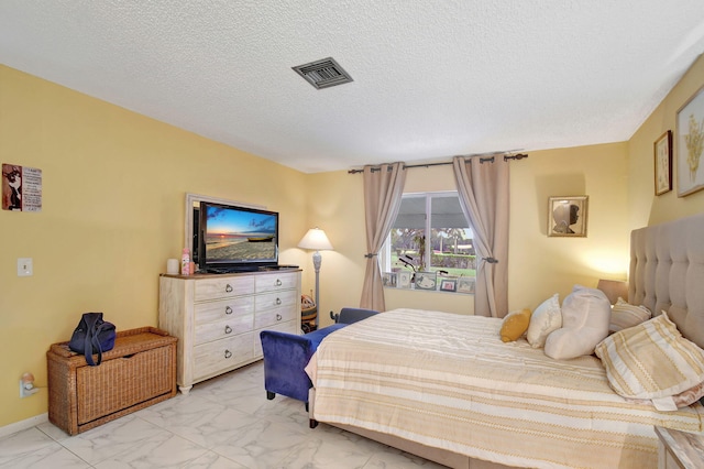 bedroom with marble finish floor, visible vents, a textured ceiling, and baseboards