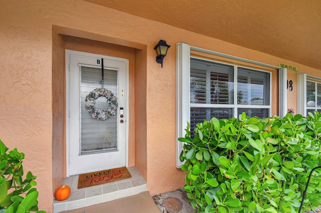 entrance to property featuring stucco siding