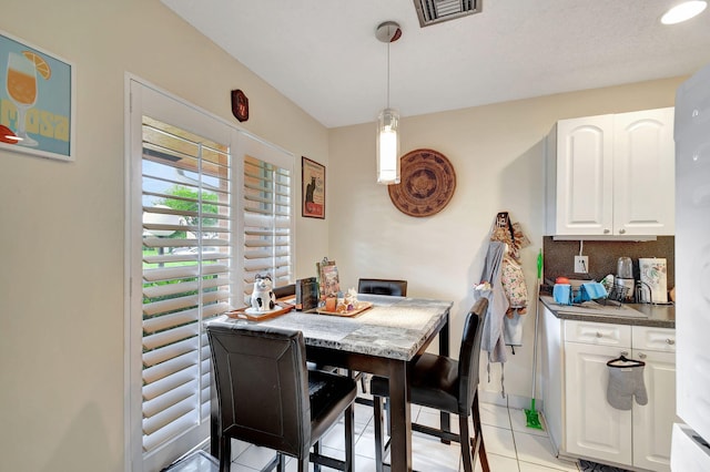 dining space with light tile patterned floors, baseboards, and visible vents