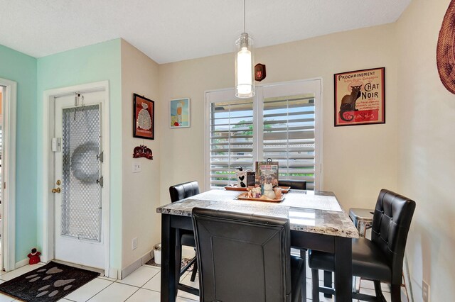 dining space with light tile patterned flooring and baseboards