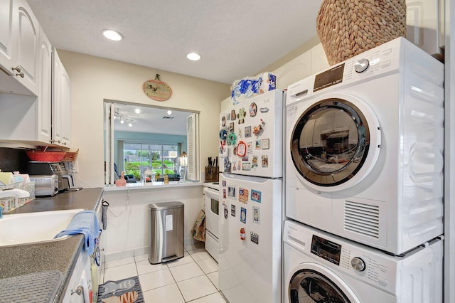 washroom featuring light tile patterned floors, laundry area, a textured ceiling, stacked washing maching and dryer, and recessed lighting