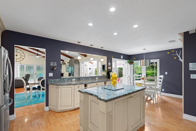 kitchen with decorative light fixtures, ceiling fan, stainless steel refrigerator, and french doors