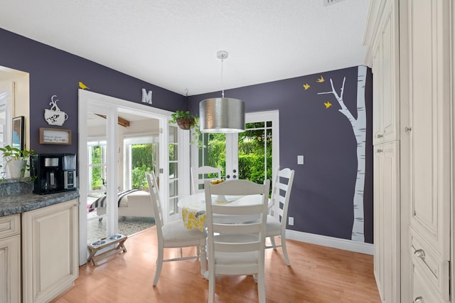 dining area featuring light wood-type flooring, french doors, and a wealth of natural light