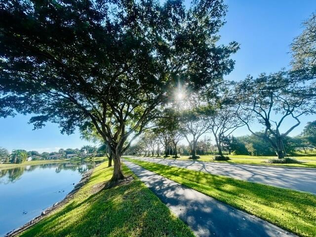 surrounding community with a yard and a water view