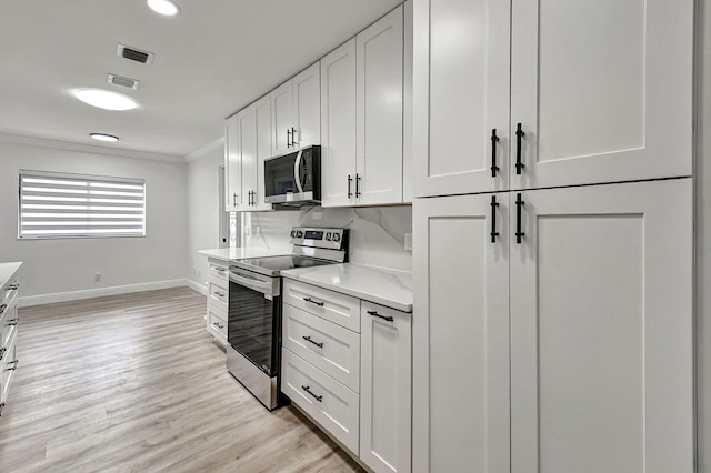 kitchen featuring crown molding, light hardwood / wood-style flooring, white cabinets, and appliances with stainless steel finishes