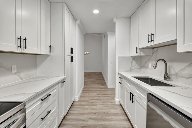 kitchen featuring white cabinetry, light stone countertops, sink, and appliances with stainless steel finishes