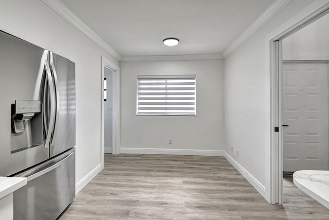 unfurnished dining area with light hardwood / wood-style flooring and crown molding