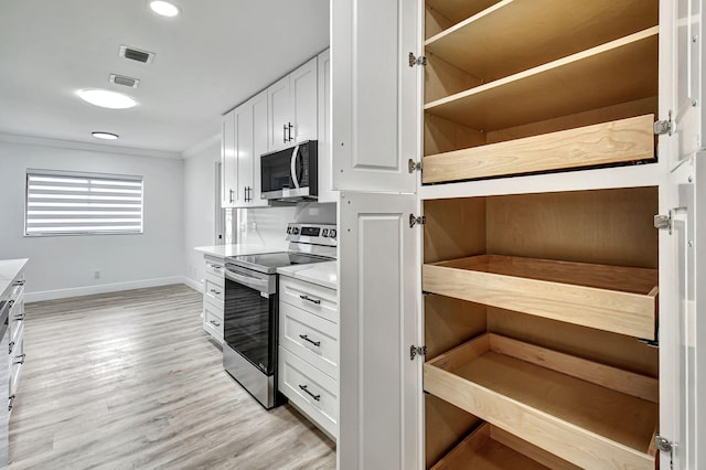 kitchen with white cabinetry, light hardwood / wood-style flooring, ornamental molding, and appliances with stainless steel finishes