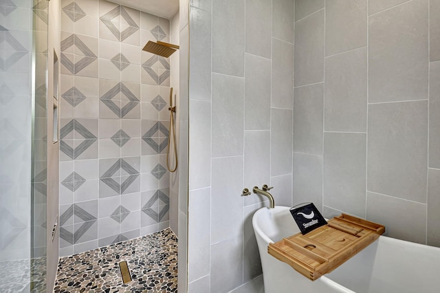 bathroom with a tile shower and tile walls