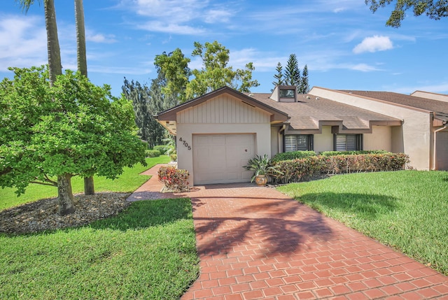 view of front of house featuring decorative driveway, roof with shingles, stucco siding, a garage, and a front lawn