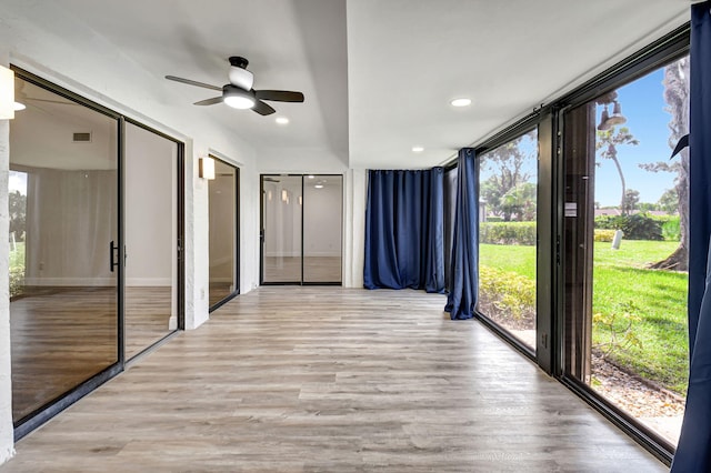 unfurnished sunroom with ceiling fan and a healthy amount of sunlight