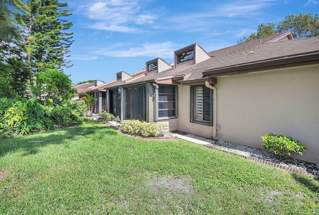 view of property exterior featuring a sunroom and a yard