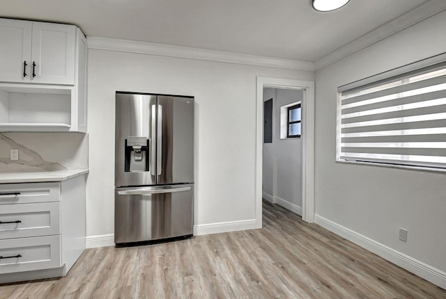 kitchen featuring white cabinets, stainless steel fridge, light hardwood / wood-style floors, and crown molding