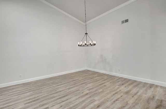 spare room with a notable chandelier, lofted ceiling, light hardwood / wood-style floors, and ornamental molding