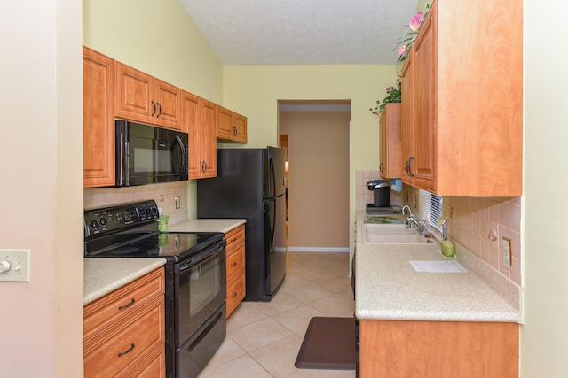 kitchen with black appliances, sink, light tile patterned floors, and tasteful backsplash