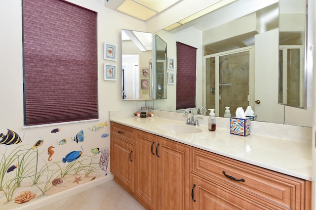 bathroom with tile patterned flooring, vanity, and a shower with door