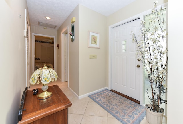 tiled foyer entrance featuring a textured ceiling