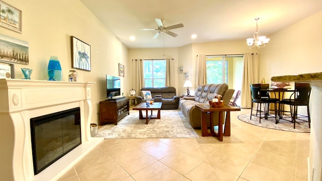 living room featuring light tile patterned floors and ceiling fan with notable chandelier