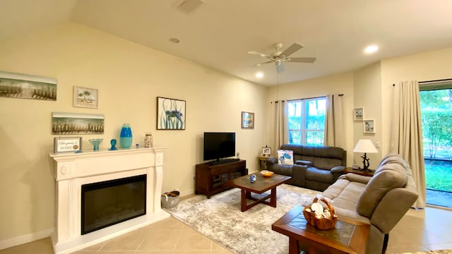 tiled living room with ceiling fan, lofted ceiling, and a wealth of natural light