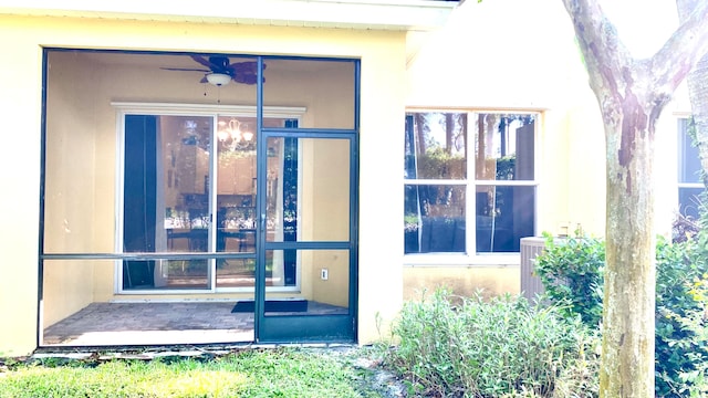 view of exterior entry with ceiling fan and central air condition unit