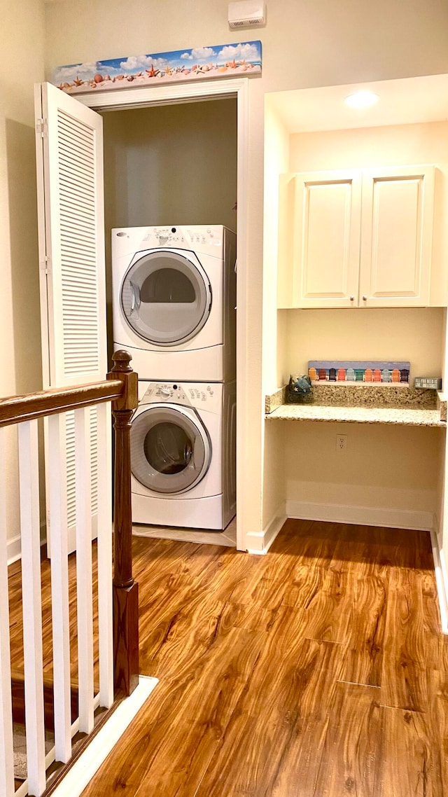 laundry area featuring light wood-type flooring and stacked washer and dryer