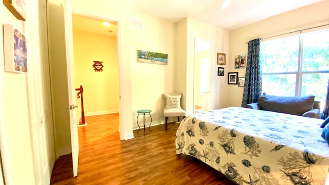 bedroom with dark hardwood / wood-style floors and ceiling fan