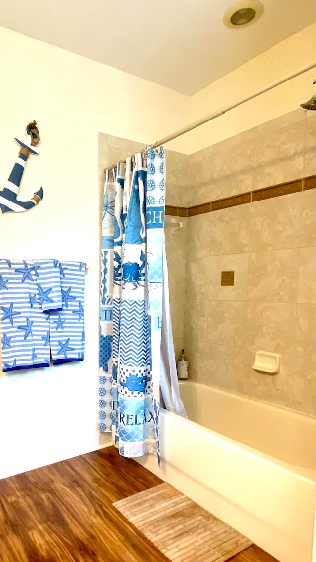 bathroom with wood-type flooring and shower / tub combo