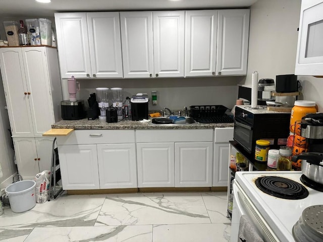 kitchen featuring white cabinetry, sink, and white appliances