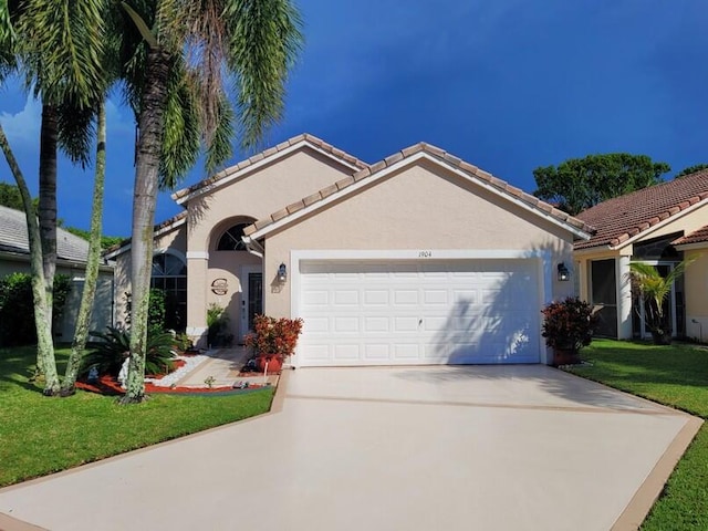 view of front of property featuring driveway, an attached garage, stucco siding, a front lawn, and a tiled roof