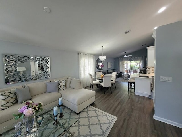 living room featuring ceiling fan with notable chandelier, lofted ceiling, and dark hardwood / wood-style floors