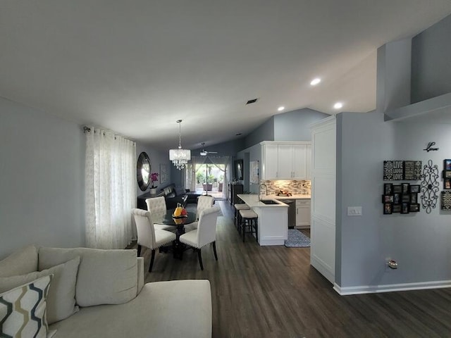 dining room with an inviting chandelier, lofted ceiling, dark hardwood / wood-style flooring, and sink