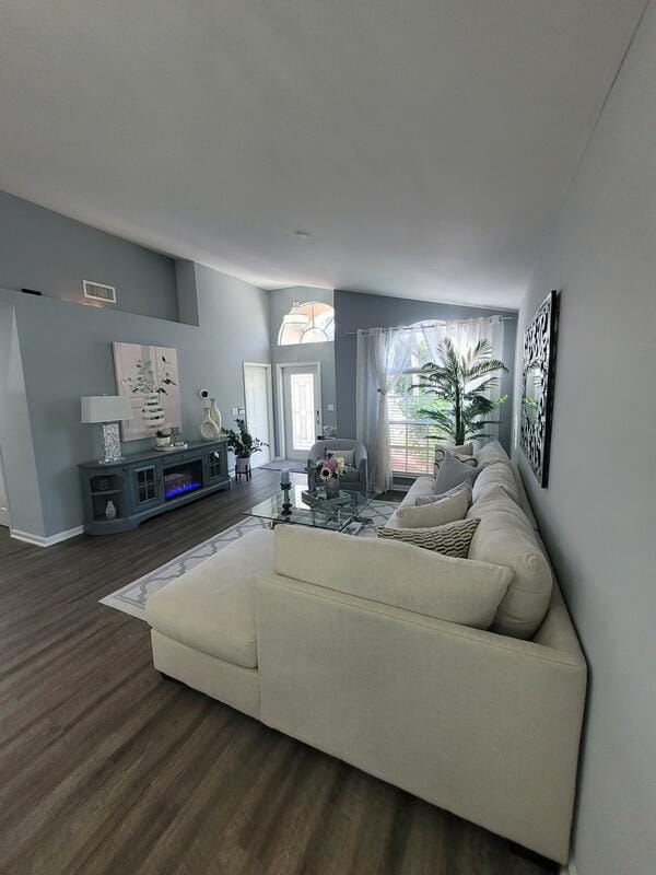 living room featuring dark hardwood / wood-style floors and vaulted ceiling