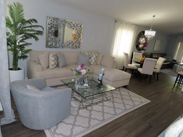 living room featuring an inviting chandelier and dark hardwood / wood-style flooring