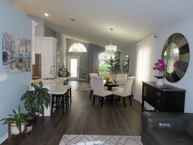 dining space with an inviting chandelier, sink, vaulted ceiling, and dark hardwood / wood-style flooring