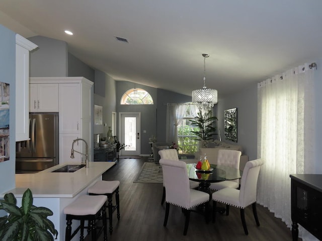 dining room with an inviting chandelier, lofted ceiling, sink, and dark hardwood / wood-style flooring