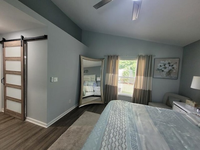 bedroom with a barn door, lofted ceiling, dark wood-type flooring, and ceiling fan