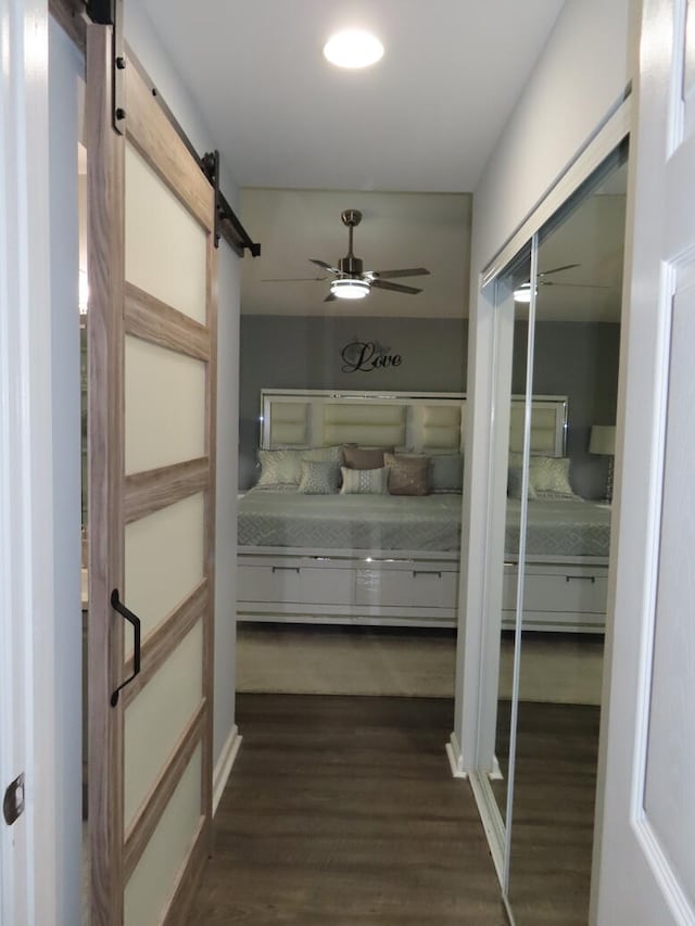 corridor featuring a barn door and dark hardwood / wood-style flooring