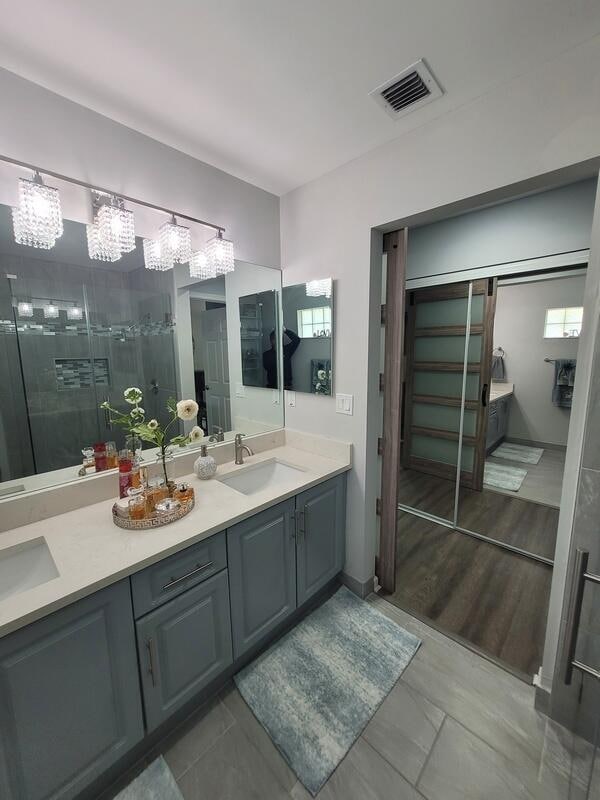 bathroom with vanity, a shower with door, and hardwood / wood-style flooring