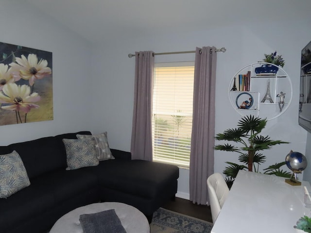 living room with lofted ceiling, plenty of natural light, and dark hardwood / wood-style flooring